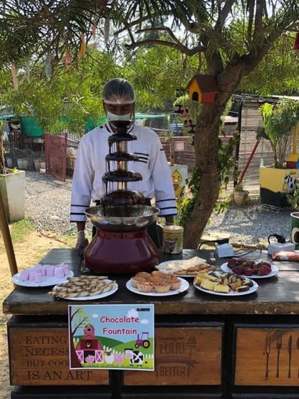 A chocolate fountain is always the star of a kids' party. Here it is set up at a farm-themed birthday, with a variety of fruits, marshmallows, and cakes for dipping.