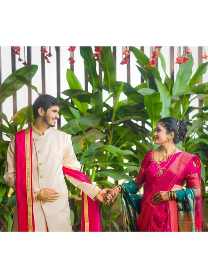 A candid moment of connection between the couple in their traditional outfits. Holding hands and sharing a look, this photo tells a story of partnership and shared heritage.