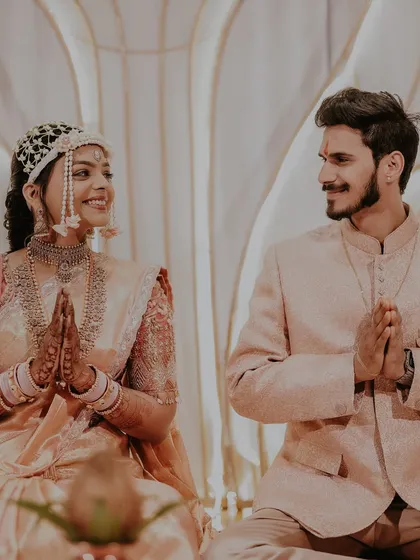 The couple sharing a moment of prayer during their engagement ceremony, adorned with our floral creations.