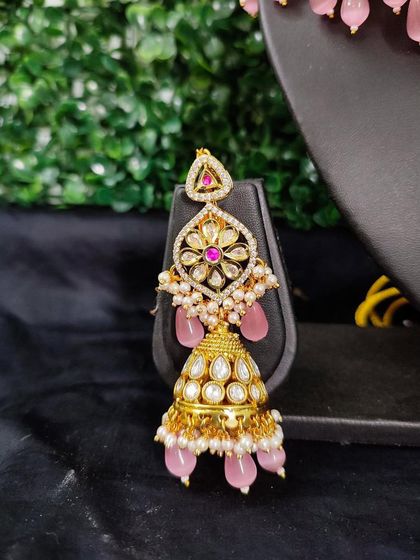 The matching jhumka earring, combining traditional kundan with modern pastel pink for a beautiful fusion look.