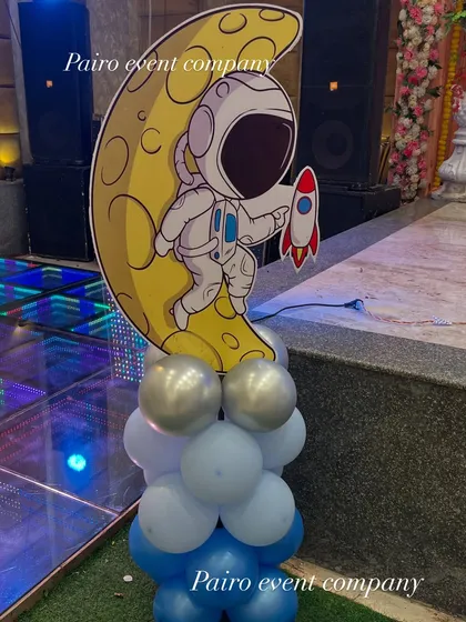 A custom prop for our space-themed party. This standalone piece features an astronaut on the moon, supported by a base of balloons, adding a great photo opportunity away from the main stage.