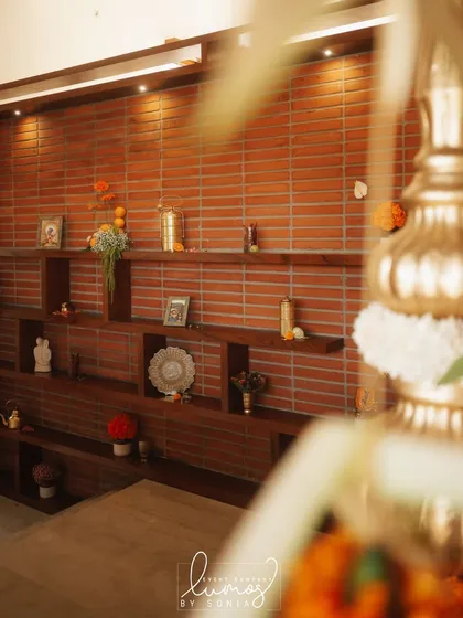 A close-up of the shelf decor, with a focus on the warm brick wall and traditional artifacts.