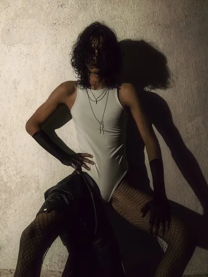 A creative pose where the model's body and his shadow create a double image. This shot is artistic and plays with form and perception.