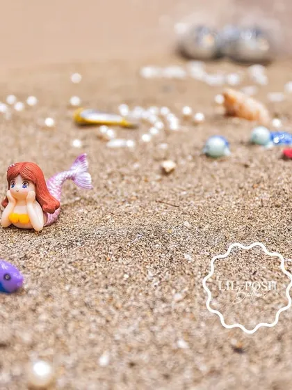 A close-up of the sand play table, showing the miniature mermaid and sea creatures hidden for kids to find.