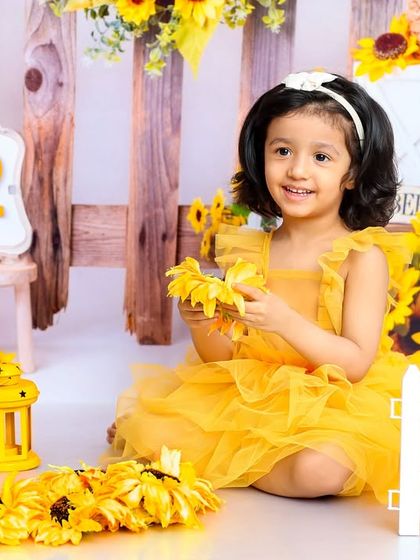 This little ray of sunshine is enjoying her beautiful sunflower garden. This theme is perfect for a bright and happy second birthday.