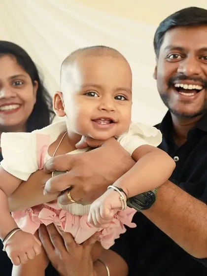 Look at that smile. We love capturing the baby's happy expressions while being lovingly held by mom and dad.