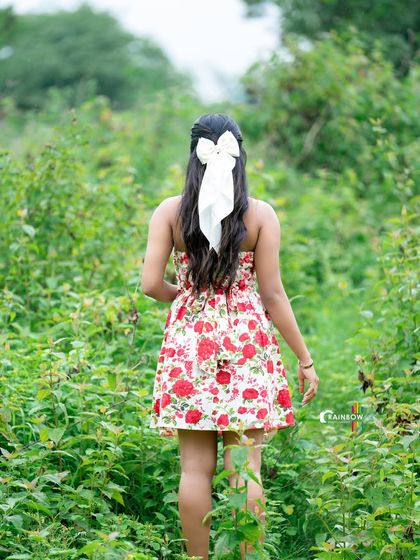 A playful shot of a model walking away through a field, showing a fun and carefree attitude.