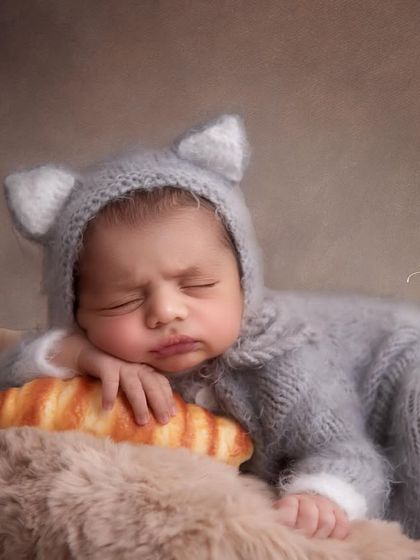 A close-up of our little baker, looking so peaceful on his croissant pillow. The soft, warm lighting and textures make this shot extra cozy.