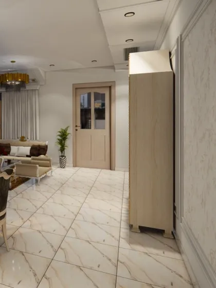 An open-concept view showing the flow from the dining area to the living space. This perspective highlights the spacious layout, consistent marble flooring, and classic wall paneling that create a cohesive and expansive feel.