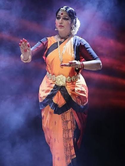 A powerful moment on stage, captured with dramatic lighting. The expression and posture convey a deep sense of emotion, which is the core of 'abhinaya' in Bharatanatyam.