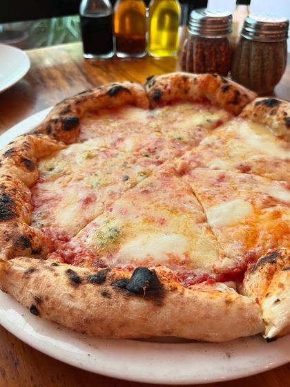 A full view of our Quattro Formaggi pizza, with its golden, bubbly cheese and perfectly charred crust.