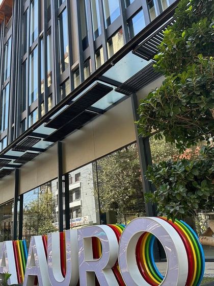 A duplicate image showing the entrance and signage of the Sattva Auro building.