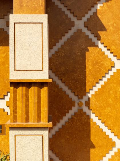 The corner of Stone Print Villa is wrapped in modular panels cast from a stone-resin composite and cut by CNC. The same unit scales across the facade, flipping at junctions to create a continuous, rhythmic pattern that articulates the building's form.