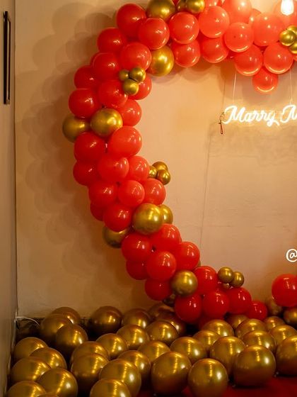 Another angle of the heart-shaped balloon arch, showing the floor covered in gold balloons for an extra touch of celebration.