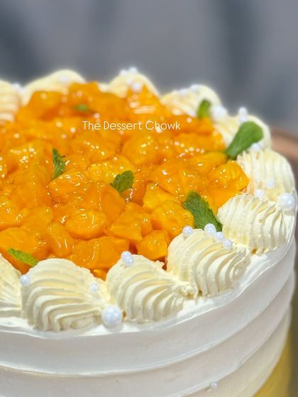 A detailed shot of the fresh mango topping on my fresh cream cake, garnished with mint leaves for a pop of color and freshness.