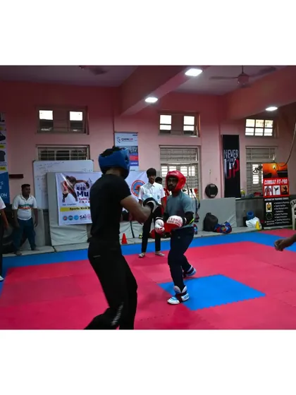 Two athletes sparring during the Mumbai City District Kickboxing Championship. With a referee overseeing the match, our fighters demonstrate the discipline and control that is central to the sport of kickboxing.
