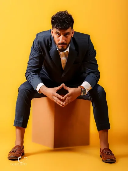 A powerful, centered pose with hands clasped. This shot conveys focus and determination, with the yellow background adding a layer of optimism and energy.
