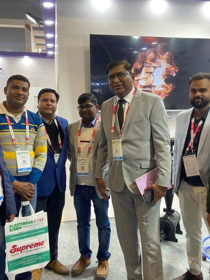 A group of enthusiastic visitors and team members posing for a photo at the PlastIndia exhibition. These events are about technology and building a strong community.