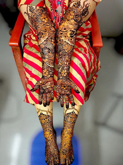 A complete bridal mehndi package. I create stunning, coordinated designs for both hands and feet, ensuring a breathtaking look for your wedding day. This design features intricate floral and paisley patterns from fingertips to elbows and across the feet.