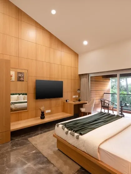 You would never guess this is a government guest house. We designed this room with a vaulted wood-paneled ceiling, marble floors, and a private balcony to create a luxurious, hotel-like experience.