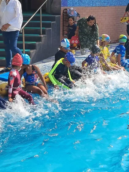 A typical group class for kids is full of energy and learning. Here, young swimmers practice their kicking techniques, an essential foundation for building strength and propulsion in the water.