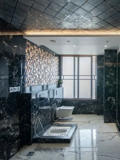 The master bathroom is a masterpiece of modern luxury, featuring dramatic black and white marble, a spacious layout, and both Indian and Western style commodes.