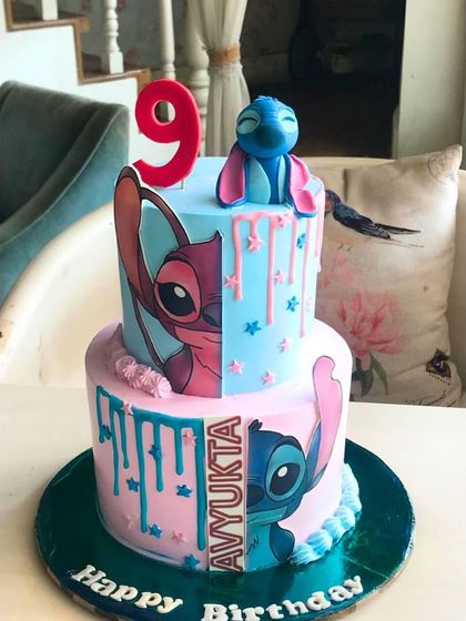 A creative two-tier Lilo & Stitch cake with a split-face design and drip effect, perfect for a fan of the beloved characters.