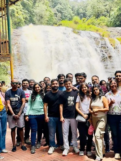 A large group photo at Abbey Falls in Coorg. It's a popular spot where everyone can enjoy the beauty of the cascading water.