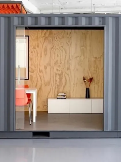 The exterior of a container transformed into a sleek, contemporary office. The industrial strength of the container is paired with refined design elements like a large sliding glass entryway, creating a professional and inviting workspace.