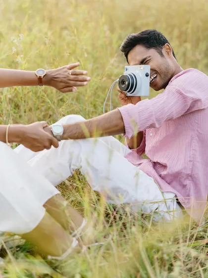Another angle of their playful moment, focusing on his laughter as he takes her picture. It’s a beautiful sequence that tells a small story of their fun-loving connection.