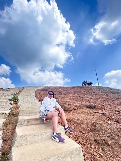 Posing on the steps leading up a hill in Mandalpatti. The vibrant red earth and bright blue sky make for a stunning photo opportunity.