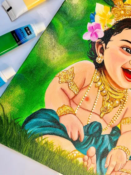 A close-up of the Bal Krishna painting, showing the intricate details on his golden jewelry and the texture of the acrylic paint on the canvas.