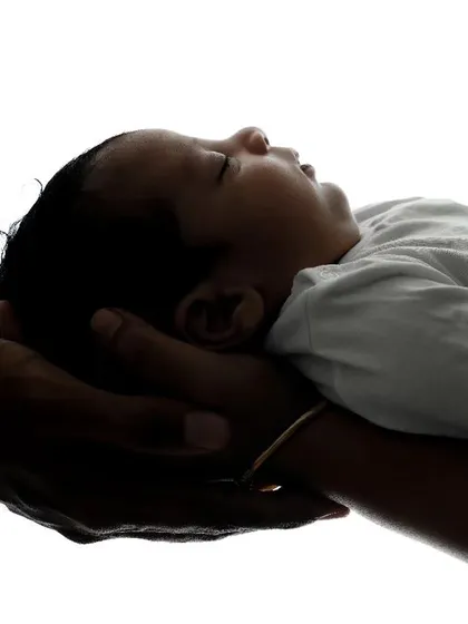 A silhouette showing a newborn resting safely in their parents' hands. This high-contrast image is a simple yet powerful way to show how small and precious they are.