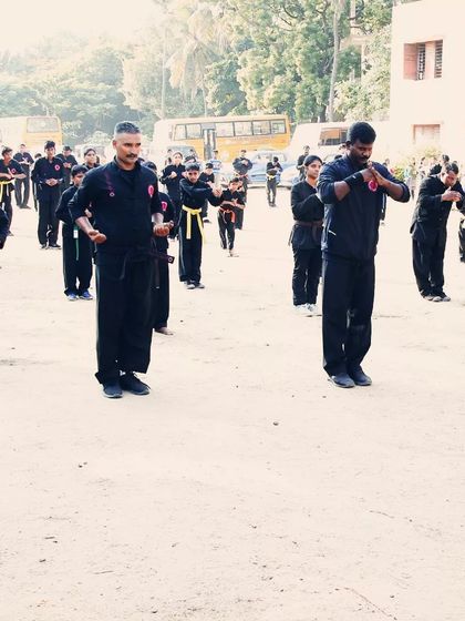 Students hold a meditative pose at the end of a drill. This practice helps calm the mind and center the body after intense physical activity.