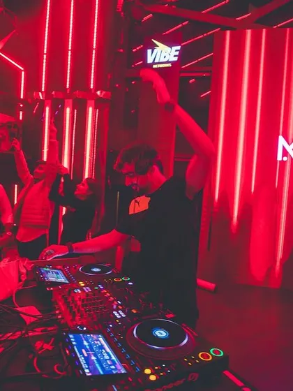 Holding up a 'VIBE' sign at the console. It's a simple message, but it's what my entire performance is built around.
