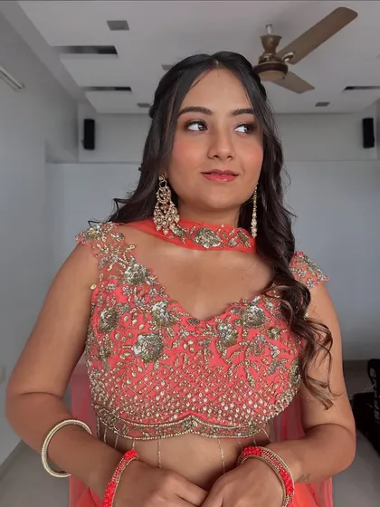 A full view of this beautiful bridesmaid look. The coral lehenga is perfectly complemented by the warm, glowing makeup.