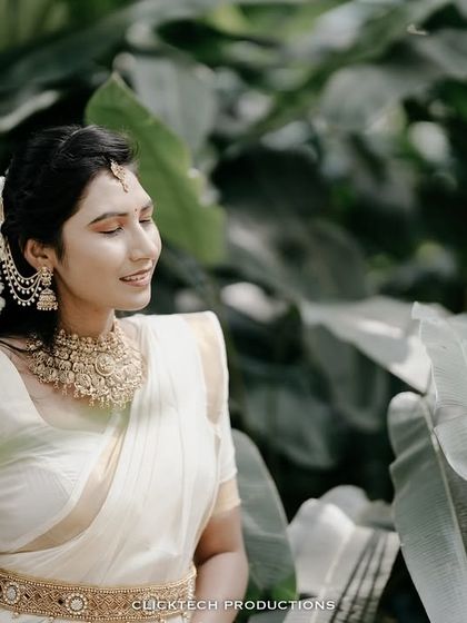 A soft, elegant portrait of the bride-to-be in her traditional saree, looking away with a gentle smile.