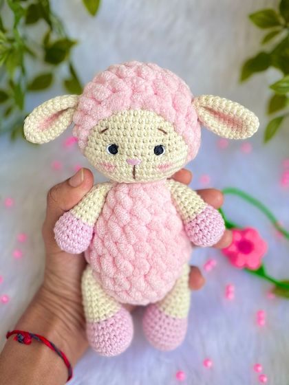 A sweet pink lamb made with a mix of regular and fluffy yarn for a lovely texture. She comes with a removable flower headband.
