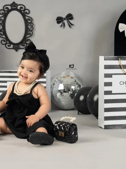 A chic and sophisticated Chanel-inspired theme for a stylish first birthday. The black and white palette with silver disco balls creates a very modern look.