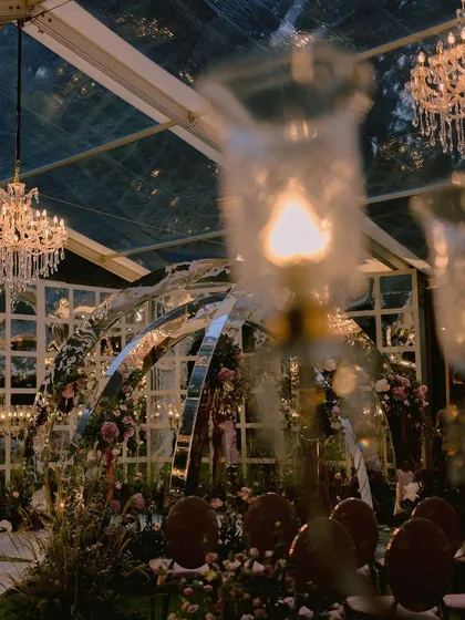 We dreamt up this one-of-a-kind contemporary mandap for Nidhi and Amit, featuring mirrored arches that reflected the lush floral gardens we created inside a clear marquee. It was a modern fairytale, built to reflect their unique personalities, even amidst a cyclone in Bangalore.