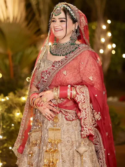 The pure joy of a bride on her wedding day. Her glowing makeup and classic red choora bangles complete this timeless look.