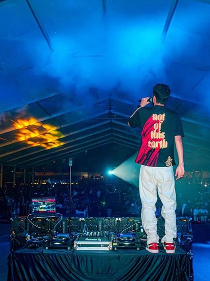 On the mic, hyping up the crowd with a backdrop of fire and ice-colored smoke.