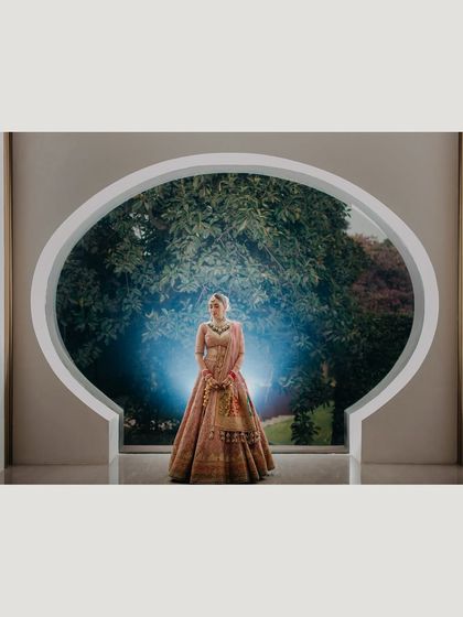 A dramatic, wide-angle shot of Ragini in front of the window, with a flash creating a powerful blue glow. This is an example of our creative lighting techniques to produce unique and memorable bridal portraits.