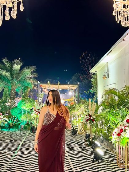 Channeling my inner Bollywood heroine in a beautiful maroon saree at a wedding reception. The grand decor and lighting add to the glamorous feel.