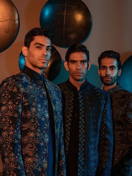 A trio of modern ensembles in shades of blue and black. Each jacket showcases a unique pattern and texture, from floral motifs to geometric embroidery, representing the diversity of our Indo-Western collection.