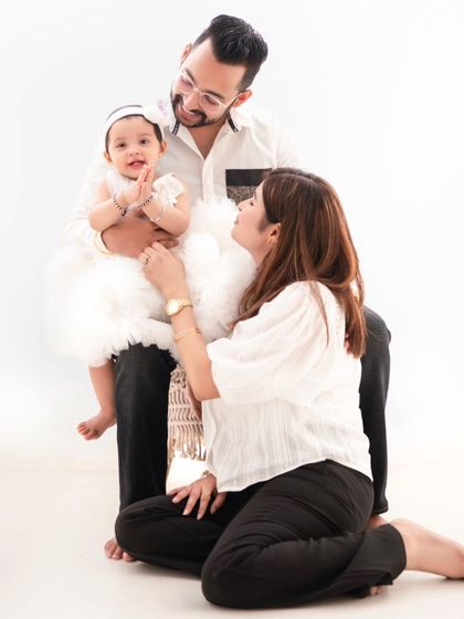 A family portrait that is full of love and affection. The way the parents look at their child creates a beautiful, emotional story.