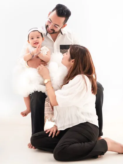 A loving family interaction. This shot captures the parents adoring their daughter, creating a memory filled with warmth and affection.