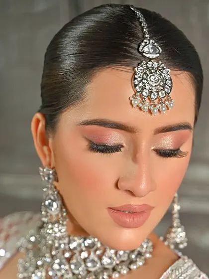 This image focuses on the soft, glamorous makeup, framed perfectly by the clean lines of the updo.