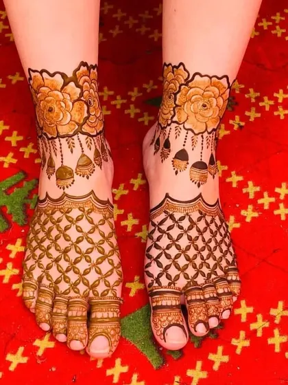 A beautiful foot mehendi design with shaded flowers and hanging jhumkas at the ankles.