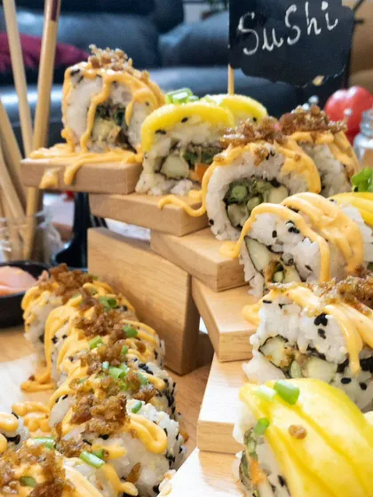 A multi-tiered sushi station is a fantastic way to display a variety of rolls. This setup allows guests to easily see and choose their favorite types of sushi.